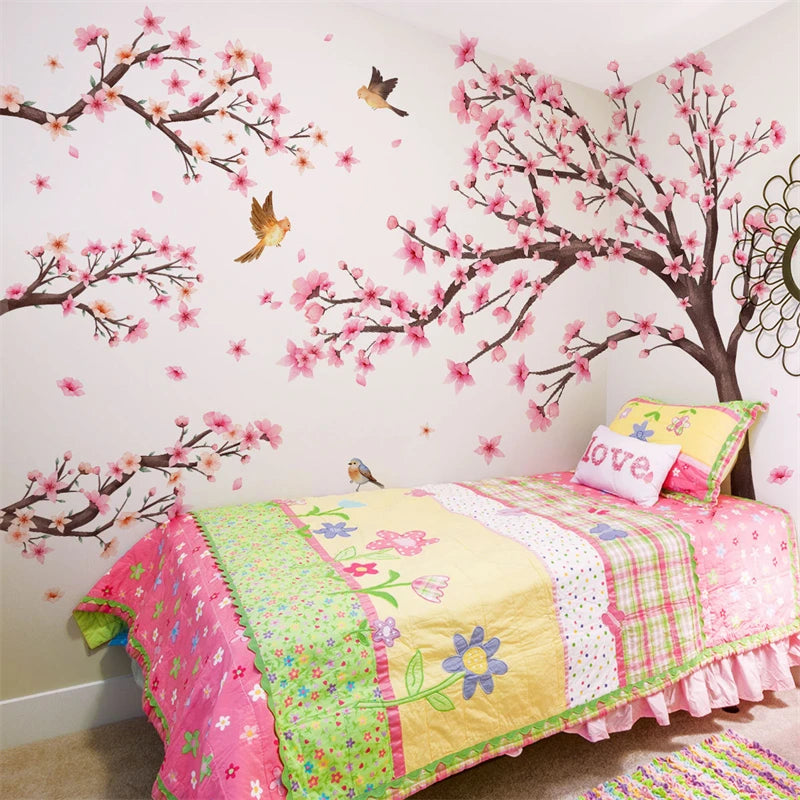 Pink cherry blossom tree wall stickers decorating a bedroom wall with pink and green floral patterns