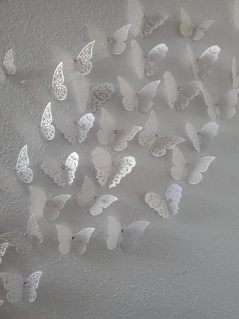 Eine Sammlung von weißen und hellgrauen 3D-Papiermäuse-Flügels-Wandaufklebern auf einer hellen Oberfläche.