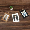 A set of rustic wooden clip photo display frames with kraft paper, featuring a potted succulent and several portrait photos.