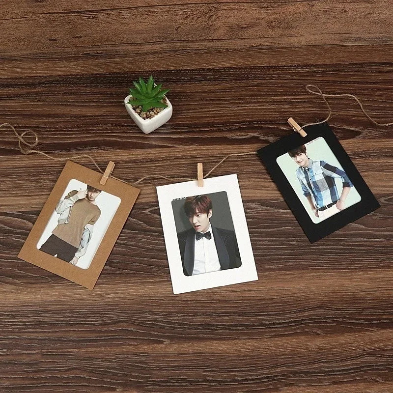 A set of rustic wooden clip photo display frames with kraft paper, featuring a potted succulent and several portrait photos.