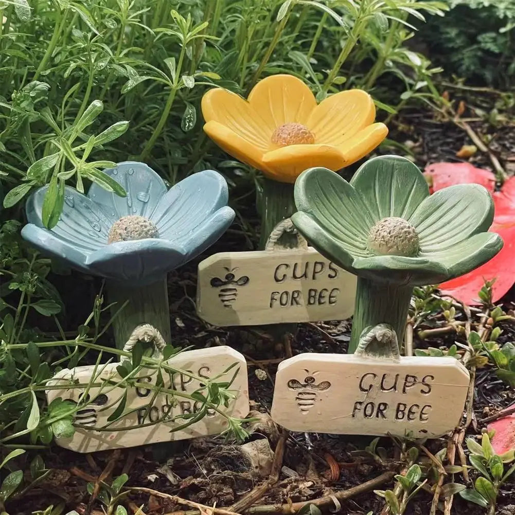 A set of decorative plant pots shaped like flowers, labeled Gups for bee and butterfly watering station.