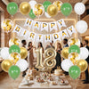 A celebration setup featuring green and gold balloons and a birthday banner on a table.
