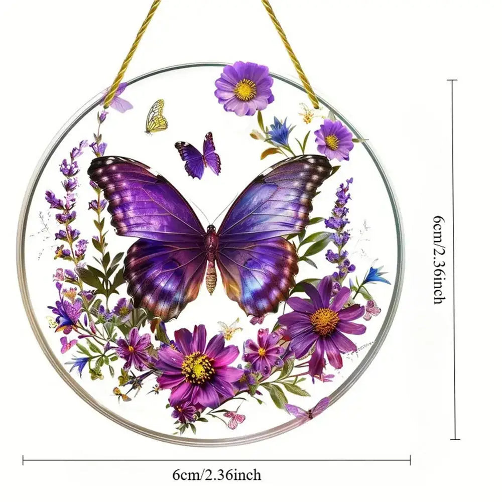 A circular acrylic hummingbird suncatcher featuring purple and yellow flowers and butterflies hanging by a gold string.