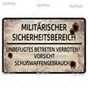A weathered metal tin sign with German text warning about a military security area and prohibiting entry.