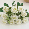 A bouquet of white artificial roses with green leaves for wedding and decoration.