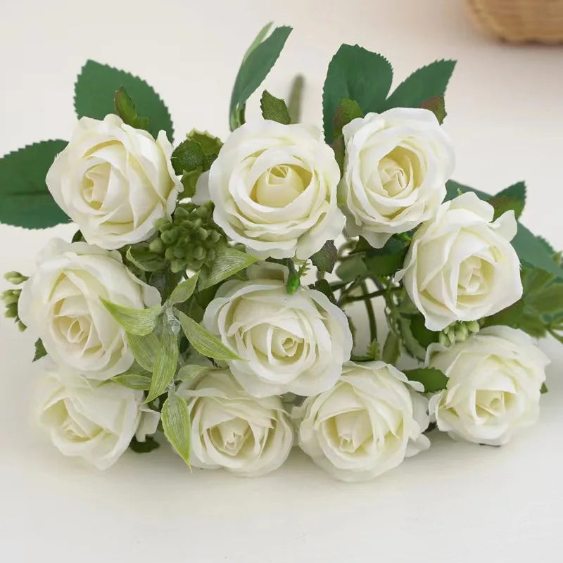A bouquet of white artificial roses with green leaves for wedding and decoration.