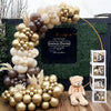 A large arrangement of brown and gold latex balloons decorated with dried grasses and leaves for a baby shower or birthday di