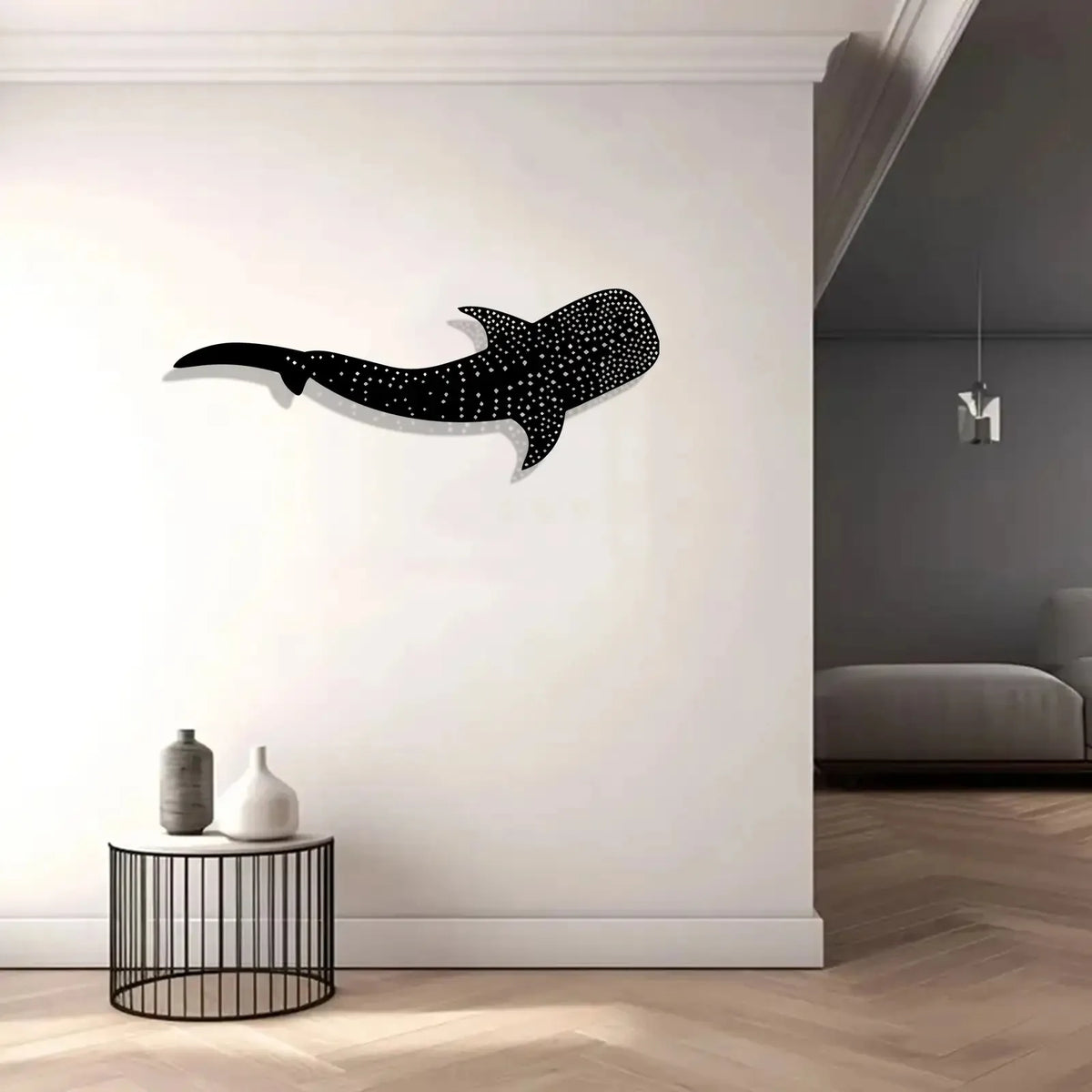 Black metal wall art depicting a silhouette of a whale shark against a white wall.