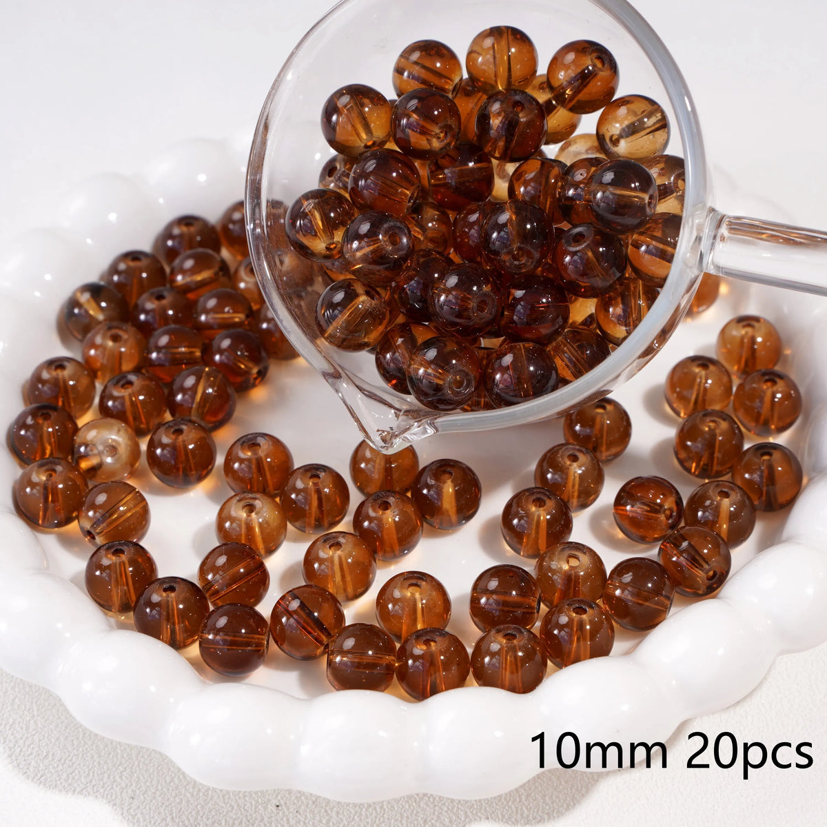 A clear glass bowl filled with round amber spacer beads for jewelry making