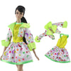 A handmade doll dress gown featuring a yellow top and white skirt with colorful stars and moons, accented by bright lime gree