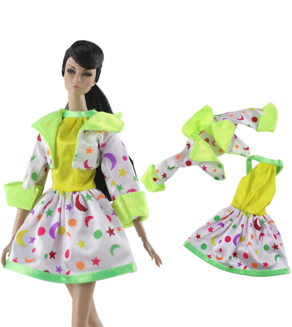 A handmade doll dress gown featuring a yellow top and white skirt with colorful stars and moons, accented by bright lime gree