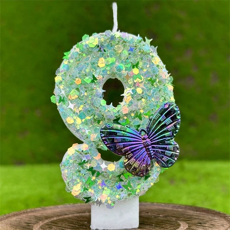 A decorative number eight made of green and iridescent sequins, featuring a purple butterfly, displayed on a white stand.