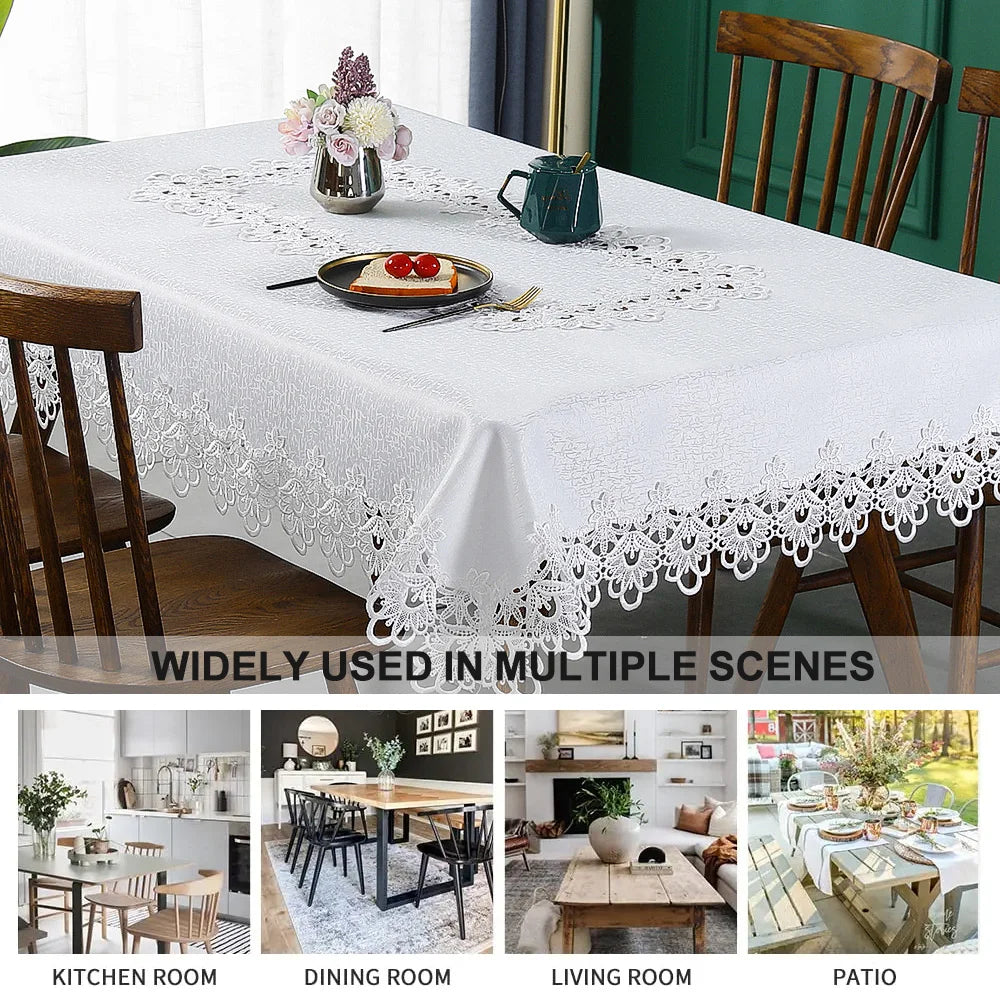 White embroidered lace tablecloth set on a wooden table with cutlery and floral accents.