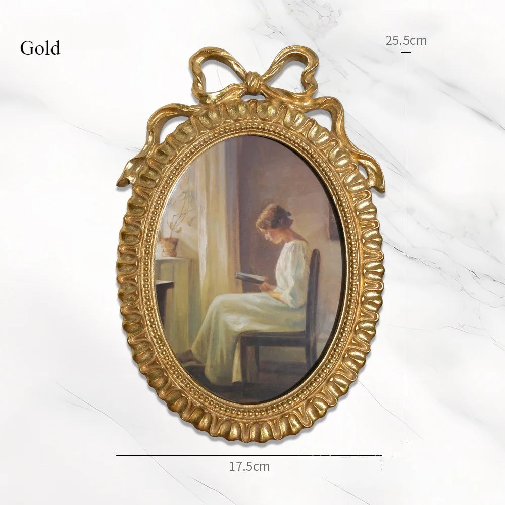 Gold vintage bowknot picture frame with an oval painting, measuring 25.5cm high and 17.5cm wide.
