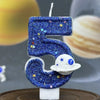 Blue glitter number 5 candle with stars and a white planet design