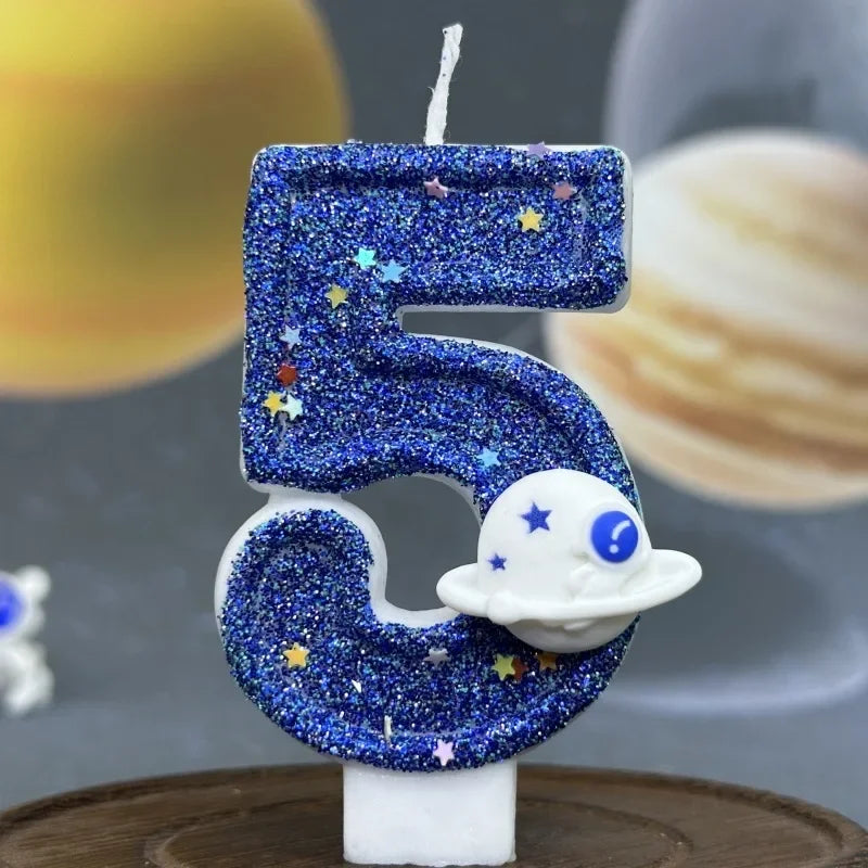 Blue glitter number 5 candle with stars and a white planet design