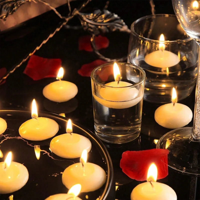 A collection of glowing white floating candles in glass holders set against a dark background.