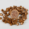 A pile of small, round, transparent wax sealing beads in a golden-brown color.