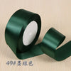 Roll of dark green silk satin ribbon for gift wrapping and craft projects