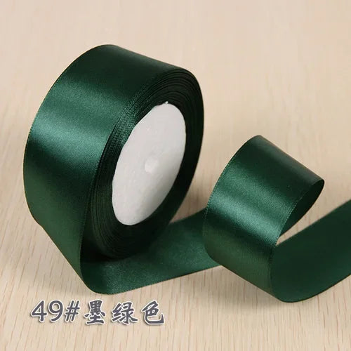 Roll of dark green silk satin ribbon for gift wrapping and craft projects
