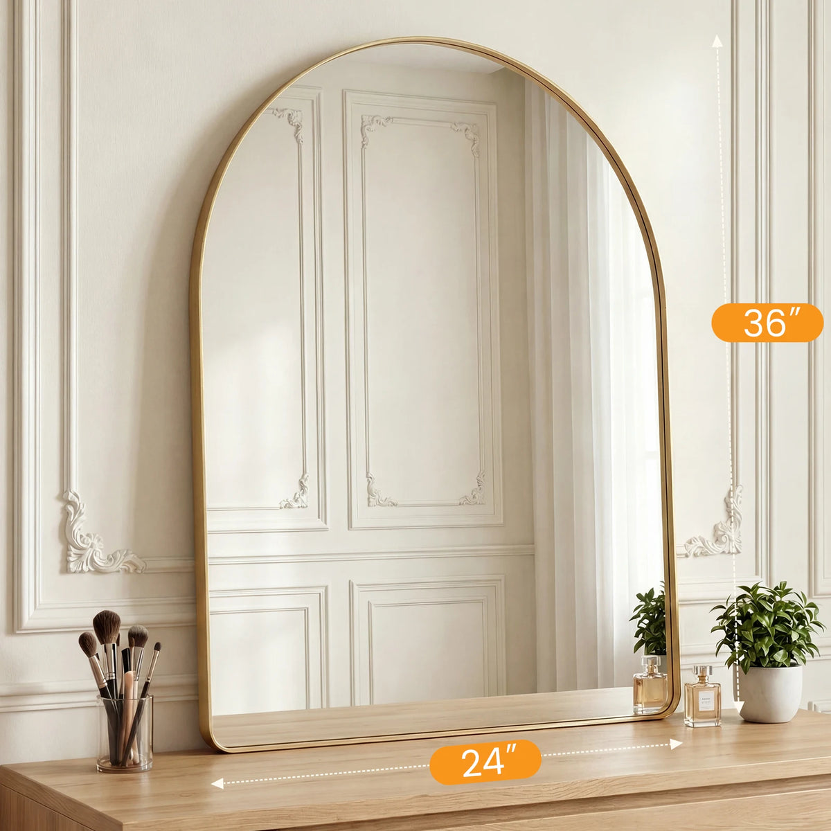 An arched full-length wall mirror with a gold frame reflecting a room interior.