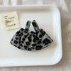 A dark gray leopard print shoulder strap skirt is displayed on a white plate next to a small note.