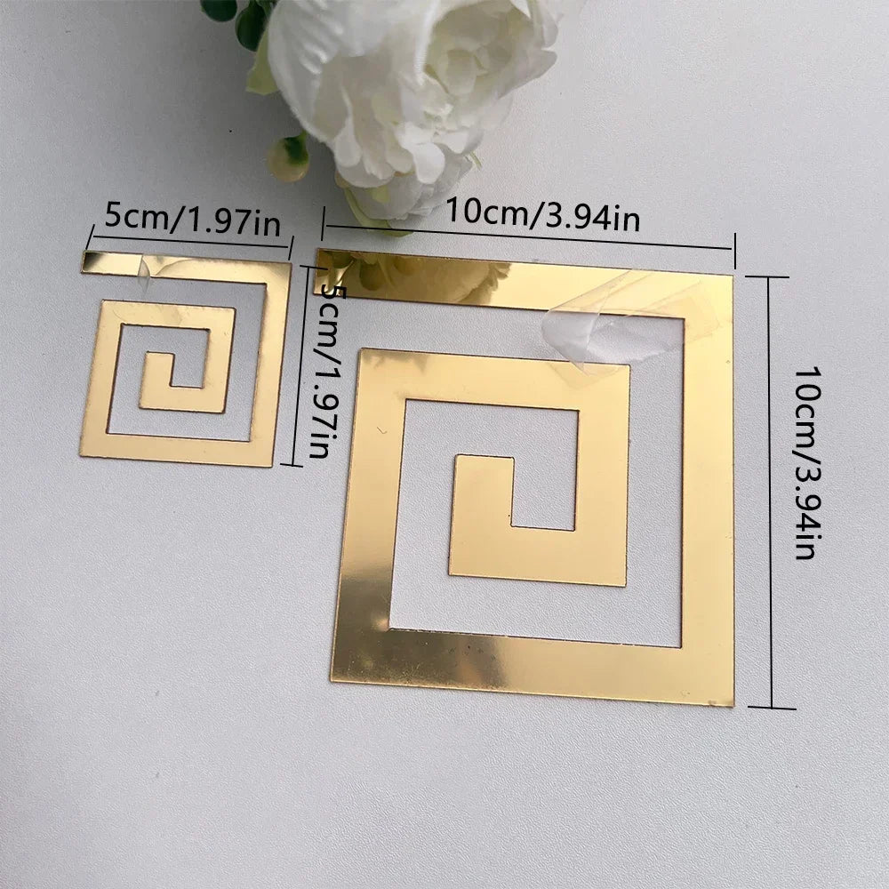 A set of gold acrylic mirror wall stickers demonstrating a swirling geometric pattern.