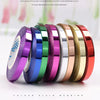 A collection of colorful plain webbing ribbon rolls in various satin colors displayed on a white background.