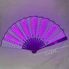 A purple glow folding LED fan with illuminated petals displayed against a light background.