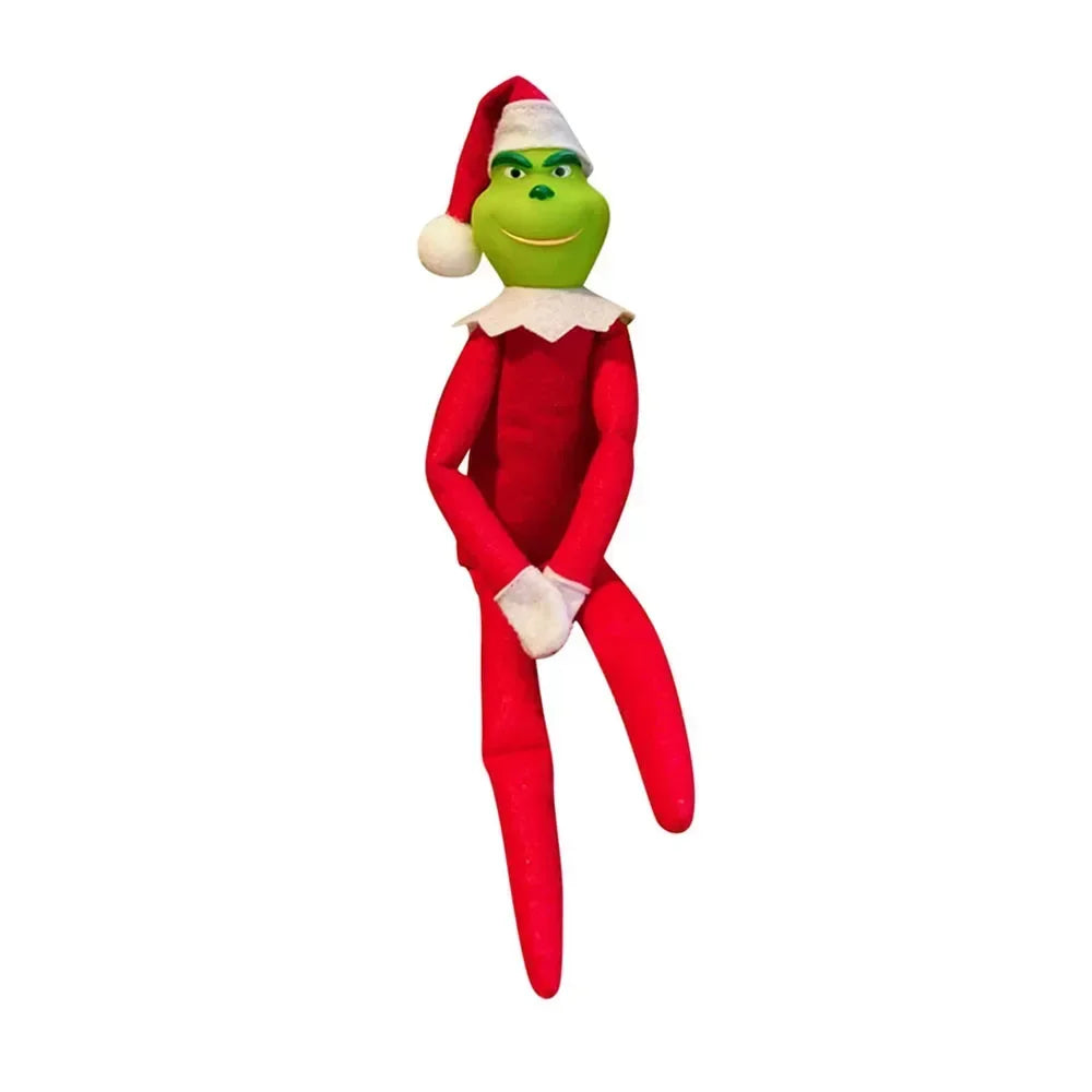 Une elfe verte en peluche avec un costume rouge et un bonnet de Père Noël.