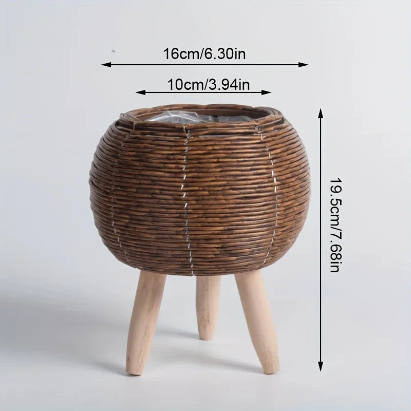 A rustic rattan planter with a round woven top and wooden legs, shown from above.