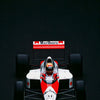 A red and white Formula 1 car is centered on a black background, viewed from the front.