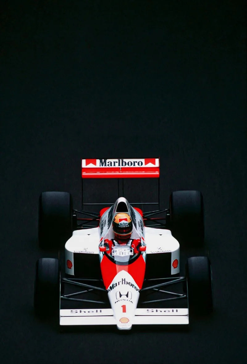 A red and white Formula 1 car is centered on a black background, viewed from the front.