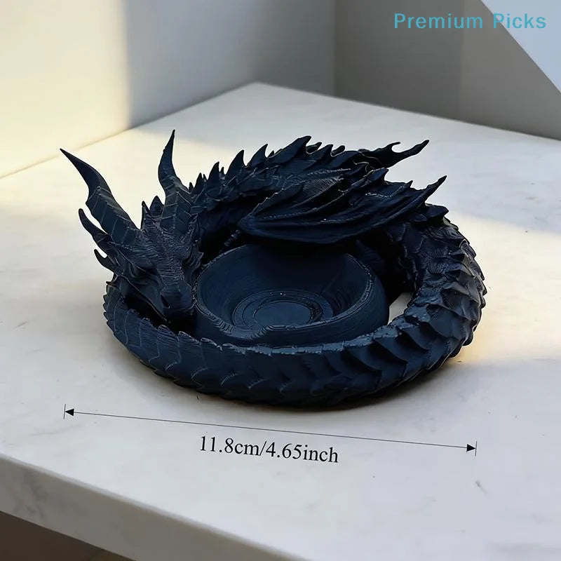A dark blue dragon design decorative tray for jewelry and small items resting on a white surface.