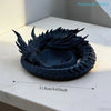 A dark blue dragon design decorative tray for jewelry and small items resting on a white surface.