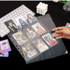 Hoja de carpeta transparente con varias photocards de Kpop y un accesorio de pompon blanco.