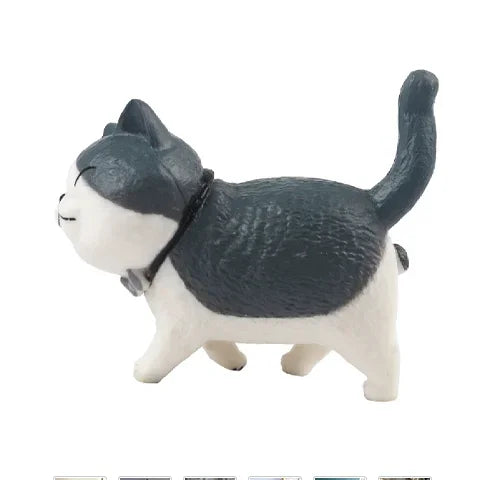 A cute gray and white cartoon cat figurine used as a refrigerator magnet.