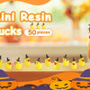 A collection of 50 yellow resin ducks with witch hats displayed on a wooden surface.