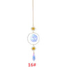 Décoration suspendue avec une sphère de cristal et un charm de gouttelette.