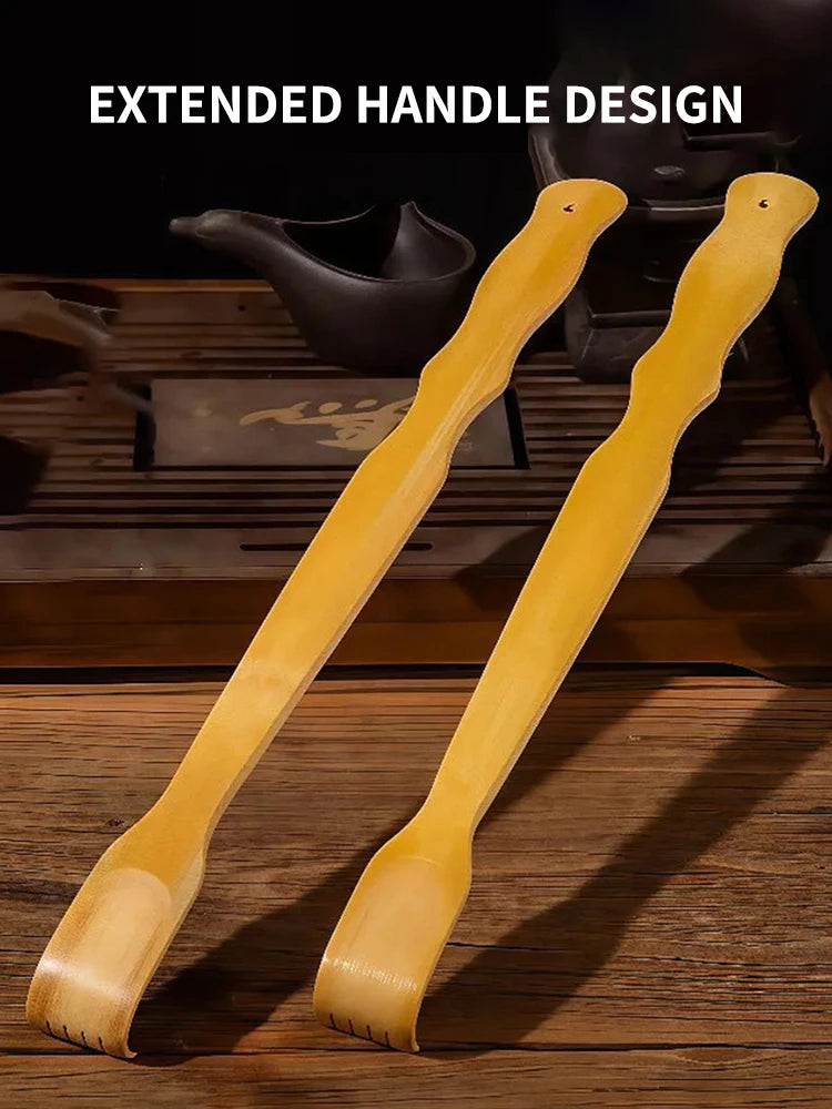 Two light yellow bamboo extended handle back scratchers shown on a wooden surface.