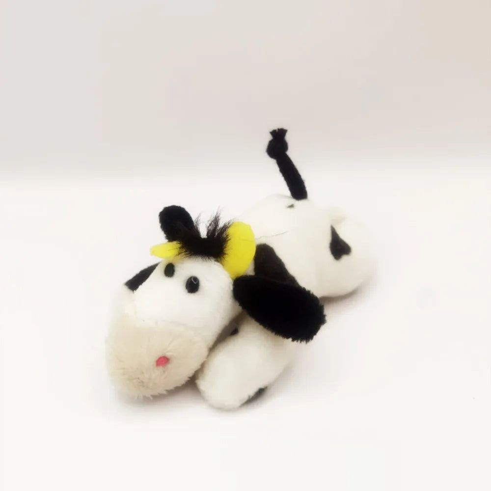 A white plush horse with black and yellow accents, used as a fridge magnet.