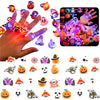 A hand holds a collection of glowing Halloween rings and various spooky themed glow lights.
