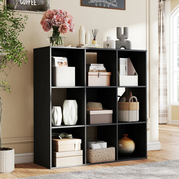 A black wooden cube storage organizer bookcase with open shelves displaying various books and decorative items.