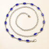 A silver chain bracelet featuring blue crystal accents, displayed on a light background.