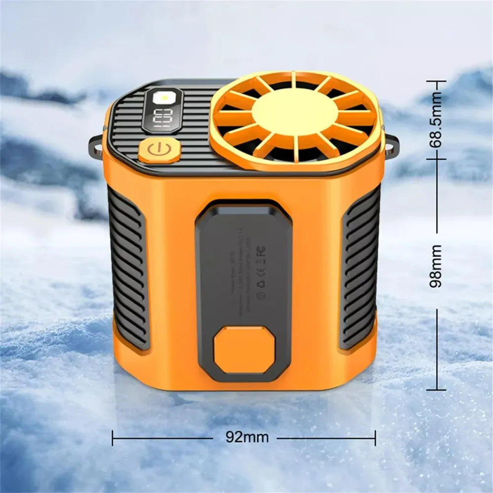 Ventilateur portable orange à taille avec grille de protection, présenté sur un fond enneigé.