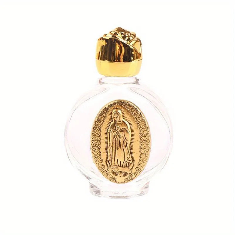 A clear glass bottle with a gold-colored stopper and an oval religious sculpture inside.