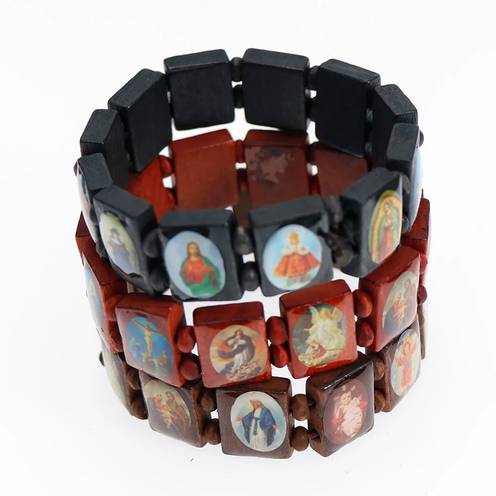 A bracelet made of natural wood beads and black stones featuring charms of the Virgin Mary and Jesus.