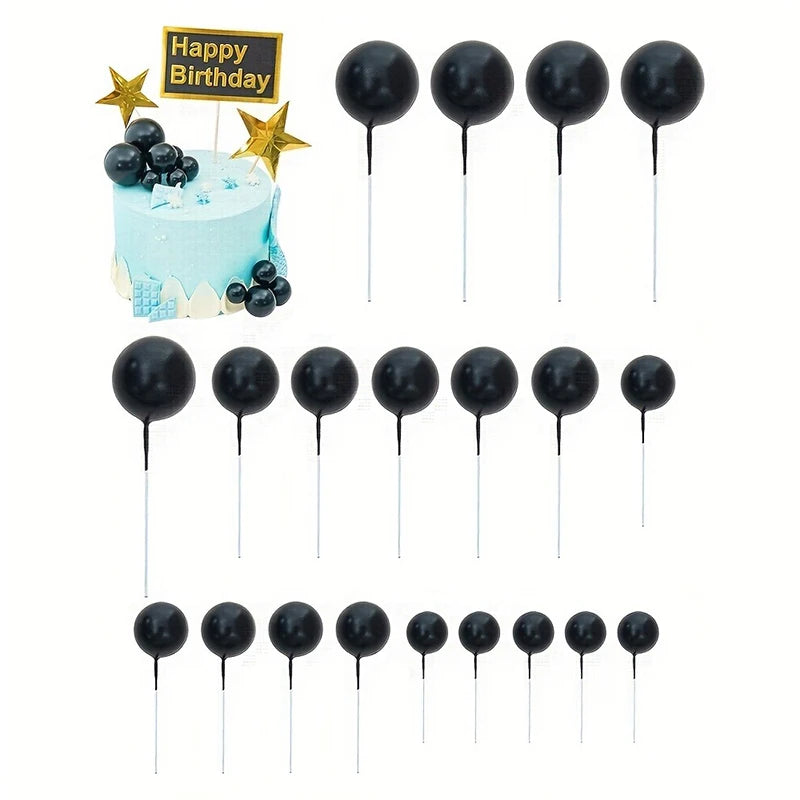 A set of twenty black mini foam ball cake toppers with gold star accents for birthday party decoration.