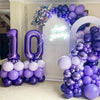 Purple foil number balloons spelling '10' and a balloon arch decoration for a birthday celebration