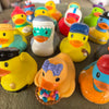 A collection of yellow and orange rubber duck bath toys scattered on a surface.